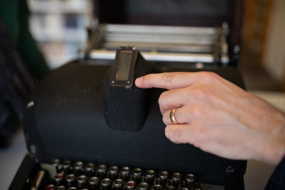 a hand points to a viewfinder on a unique Chinese typewriter